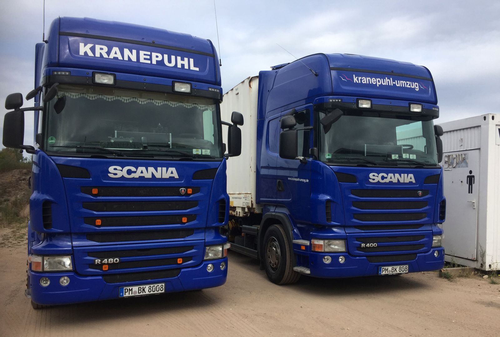 Zwei blaue Scania-Zugmaschinen mit dem Schriftzug Kranepuhl und Wechselcontainern auf dem Betriebshof in Brück