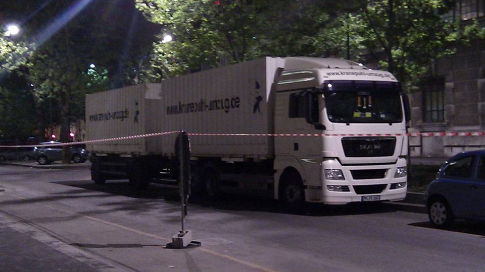 Lastzug von Kranepuhl nachts vor einer Absperrung in der Stadt
