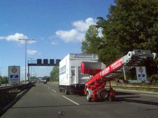 Umzugs-LKW von Kranepuhl mit angehängtem Möbellift auf der Autobahn